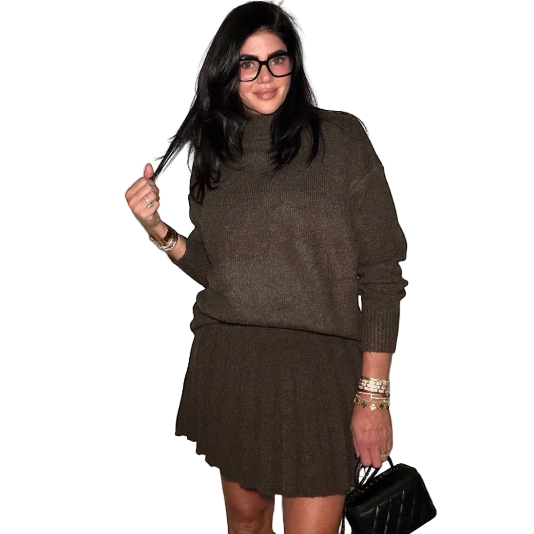 Woman wearing a brown sweater and skirt set with a plain background