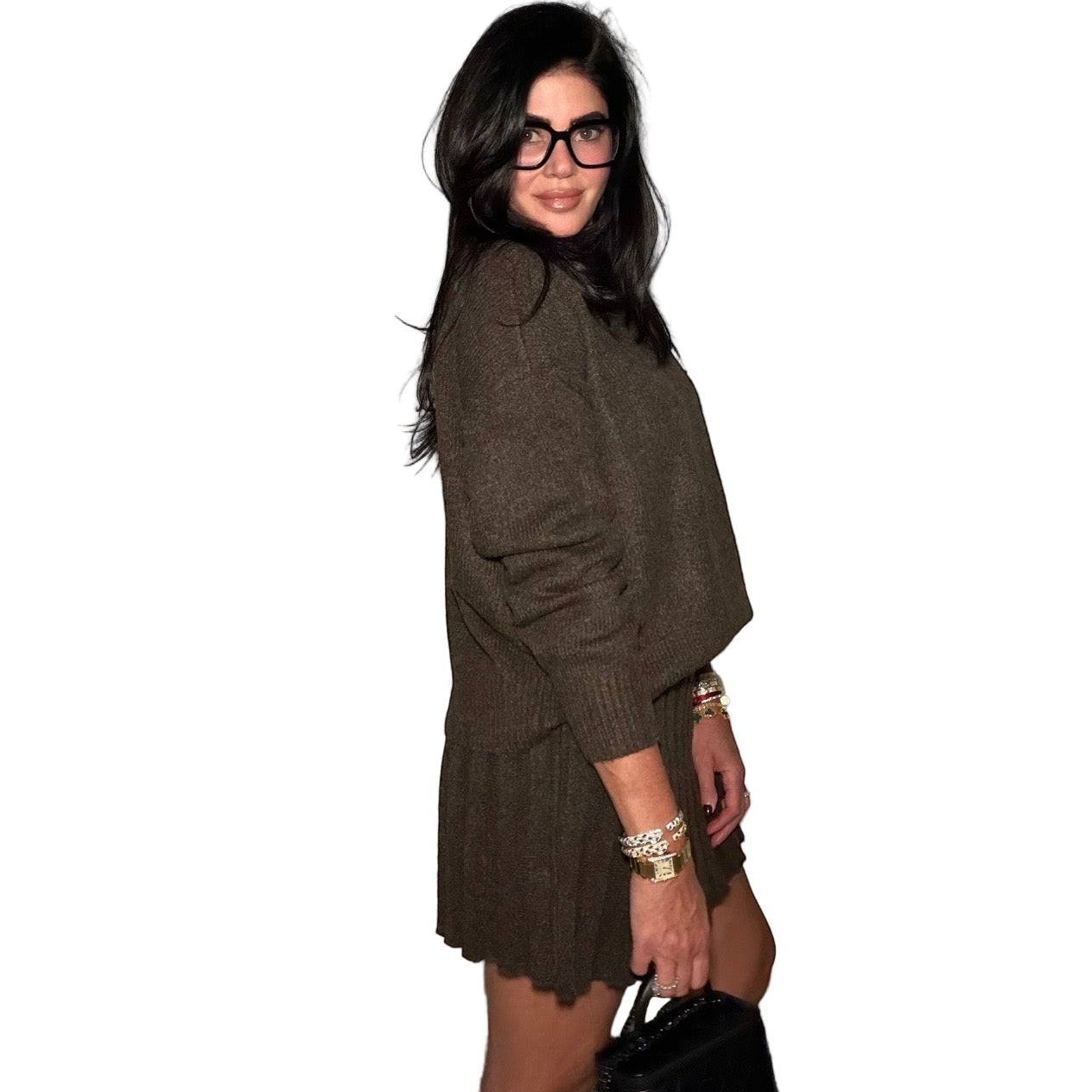 Woman wearing a brown outfit with glasses against a plain background