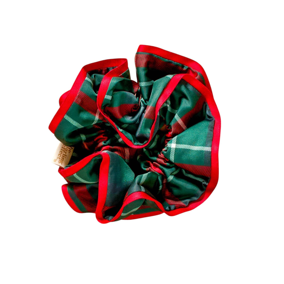 A fabric hair scrunchie featuring a green and red tartan plaid pattern with a solid red trim, shown on a plain white background.