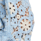 Close-up of a blue and white crocheted fabric with a geometric pattern.
