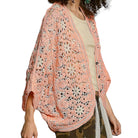Woman wearing a orange crochet cardigan on a white background