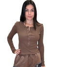 Woman wearing a brown long-sleeve top on a white background