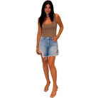 Woman wearing a brown tank top and denim shorts on a white background