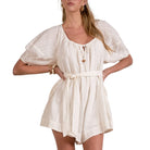 Woman wearing a white dress with a subtle pattern on a white background