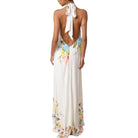 Woman wearing a floral halter neck dress on a white background
