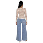 A woman shown from the back wearing a beige lace long-sleeve crop top and light blue wide-leg jeans against a plain white background.