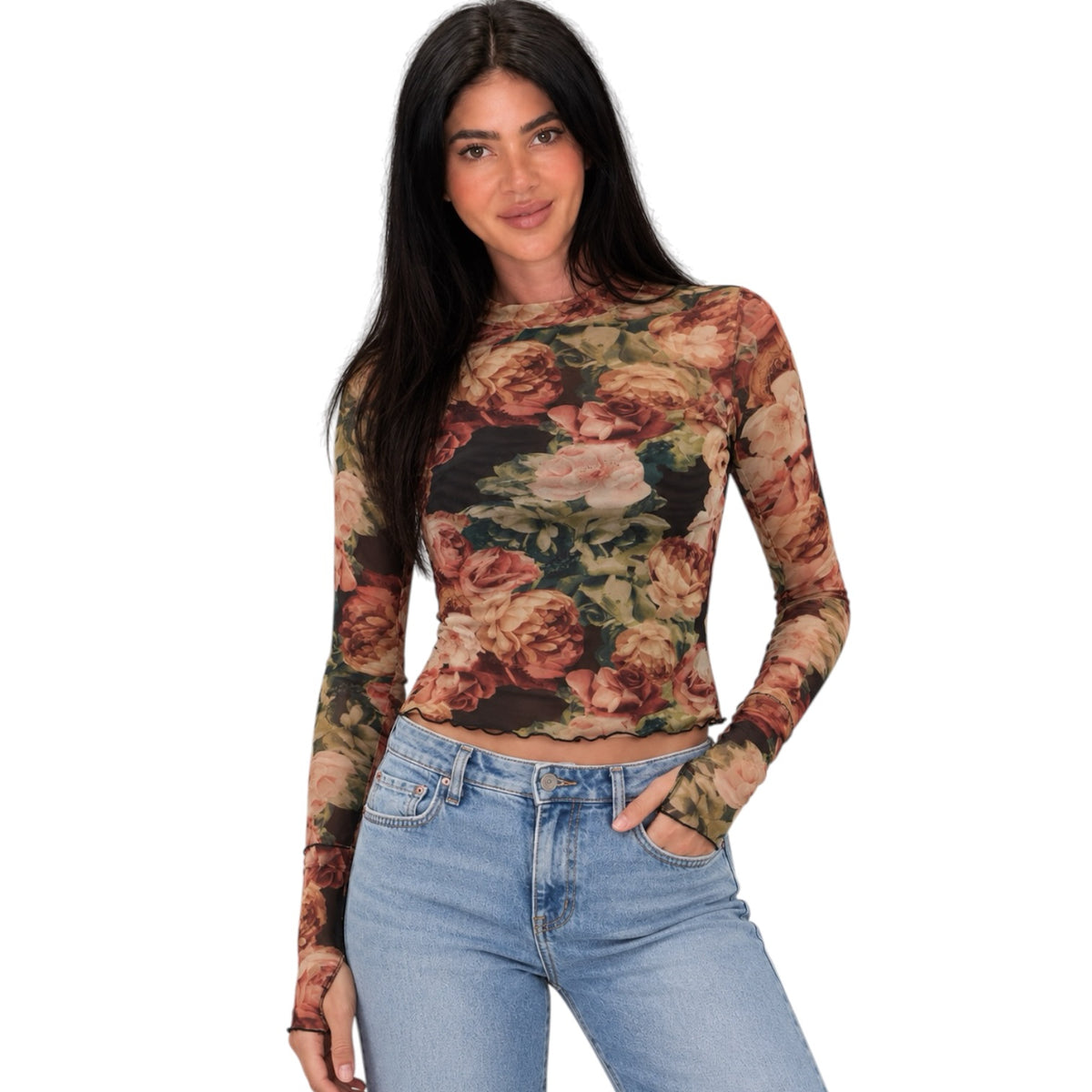 A woman modeling a long-sleeve crop top with a vintage floral print in muted red, beige, and brown tones, paired with light blue jeans against a plain white background.