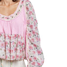 Floral blouse with pink trim on a white background