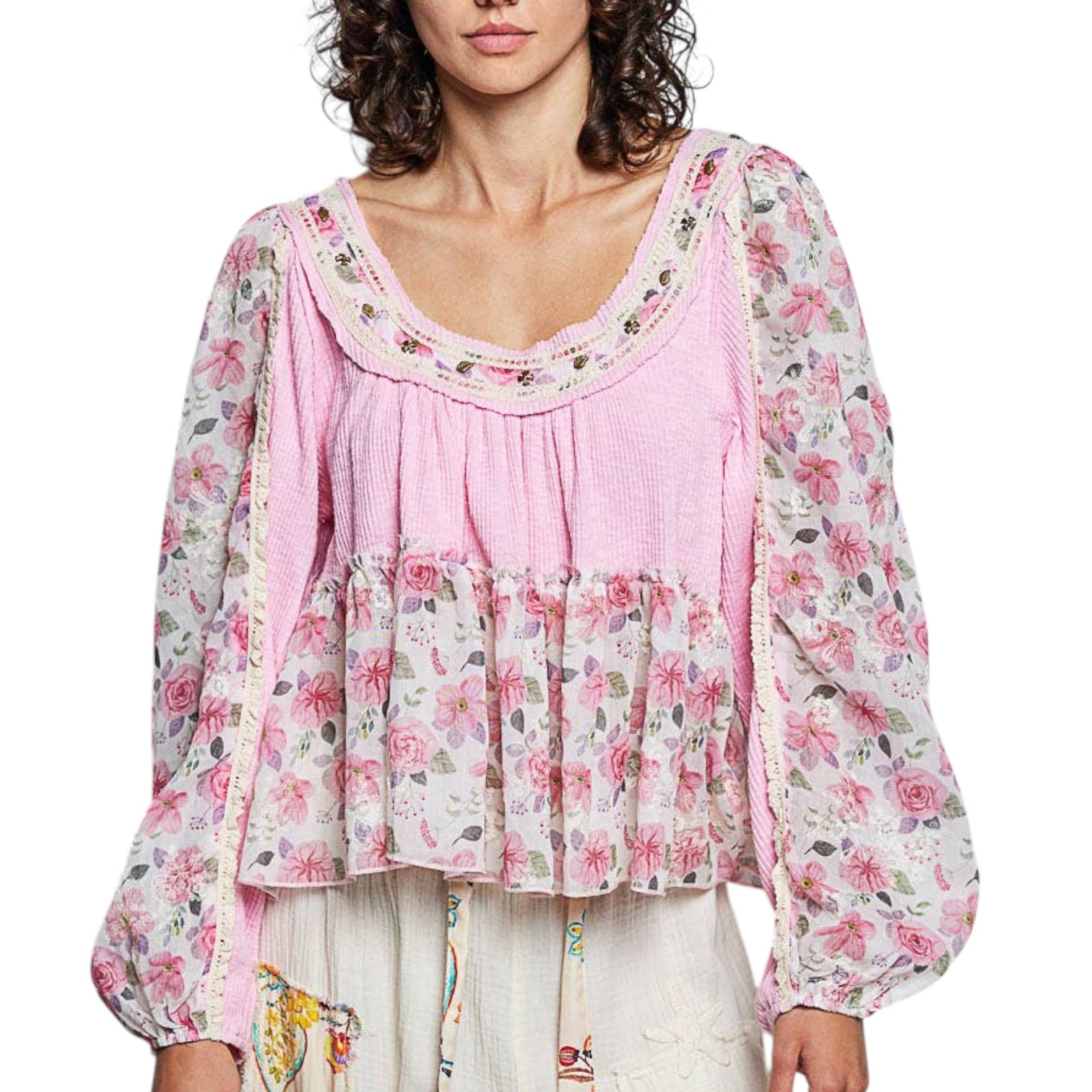 Woman wearing a floral blouse with a pink layer over a white background