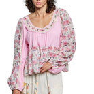 Woman wearing a pink floral blouse with a white background