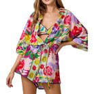 Woman wearing a colorful floral romper on a white background