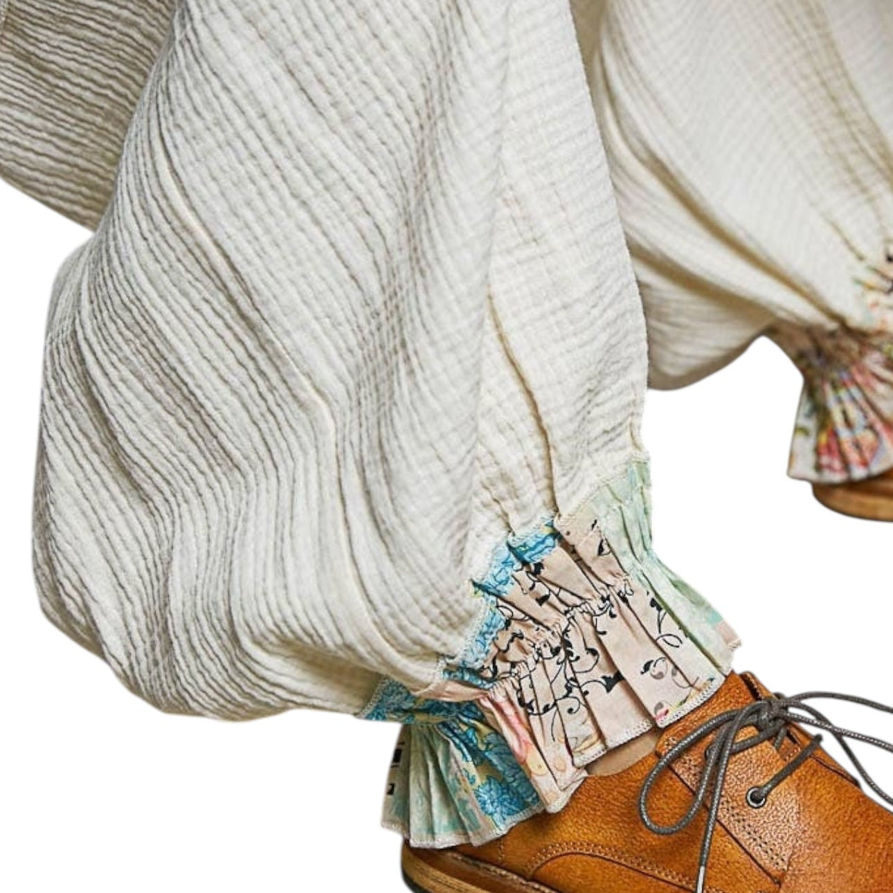 Close-up of brown shoes with ruffled pants featuring musical notes and text.