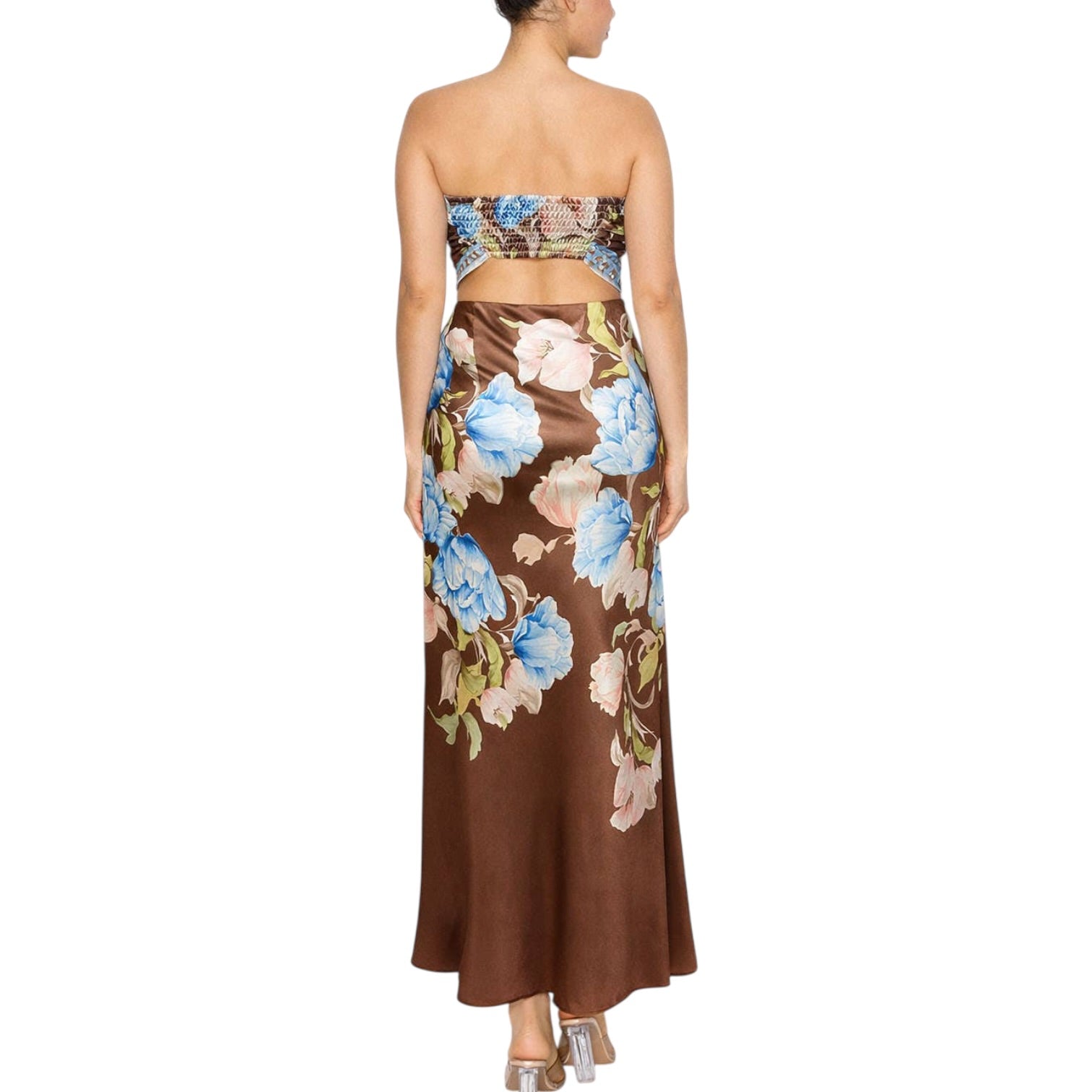 Woman wearing a floral strapless top and brown floral skirt on a white background