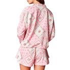 Pink quilted pajama set with floral pattern on a white background