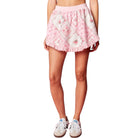Pink floral skirt worn by a person on a white background