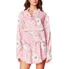 Pink quilted top with floral patterns on a white background