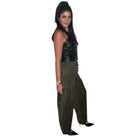 Woman wearing a black sleeveless top and green cargo pants on a white background