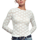 Woman wearing a white lace long-sleeve top on a white background