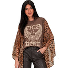 A woman modeling a brown graphic t-shirt with leopard-print sleeves, featuring an eagle design and the words 'FREE BIRD'.