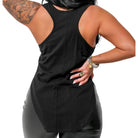 Person wearing a black sleeveless top and gray pants on a white background