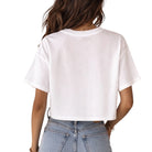 Person wearing a white t-shirt and blue jeans on a plain background