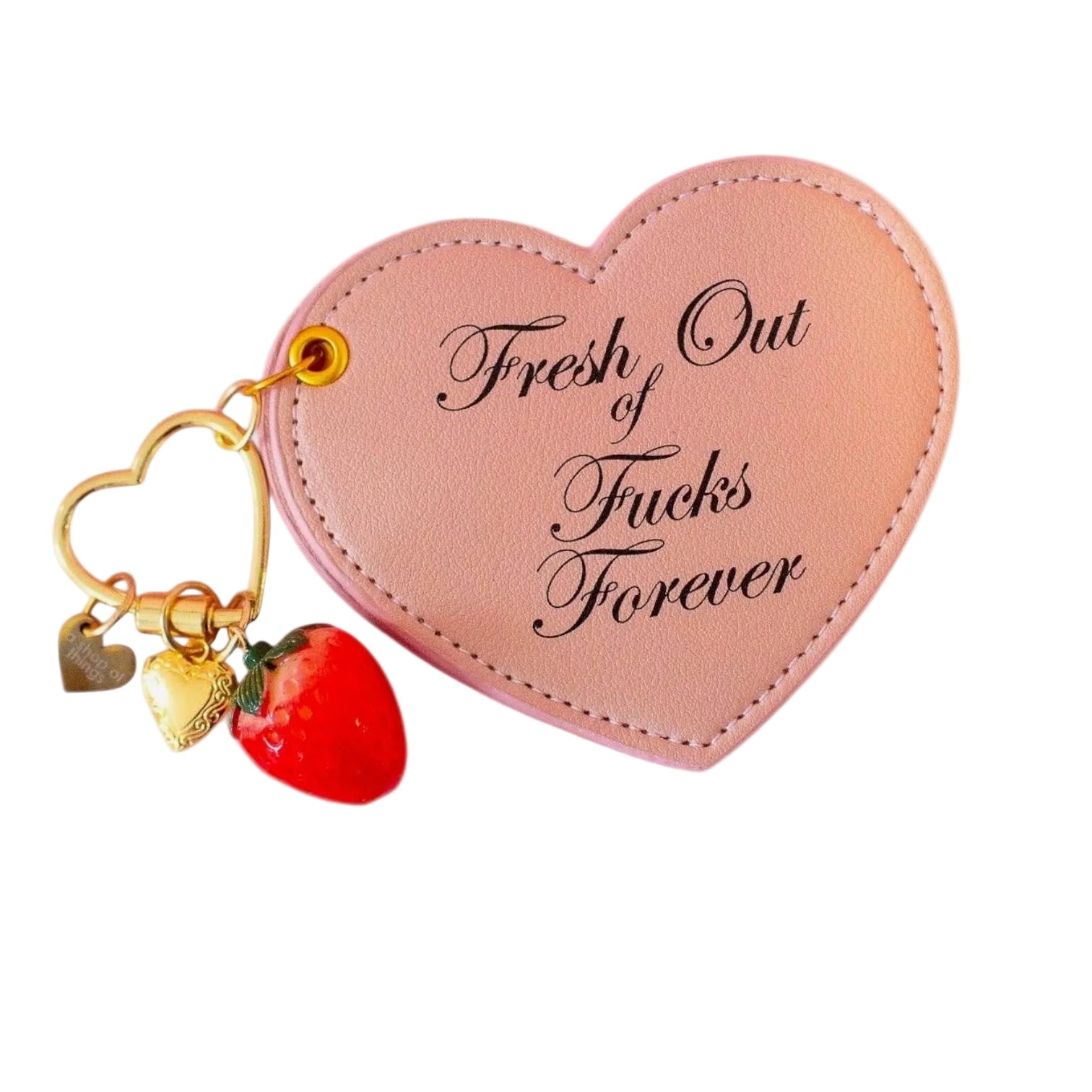 Heart-shaped pink keychain with gold heart charm and strawberry, featuring text on a white background