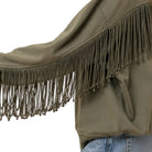 An olive green fringed jacket or shrug with long hanging fringe along the sleeve, shown on a model wearing blue jeans against a plain white background.