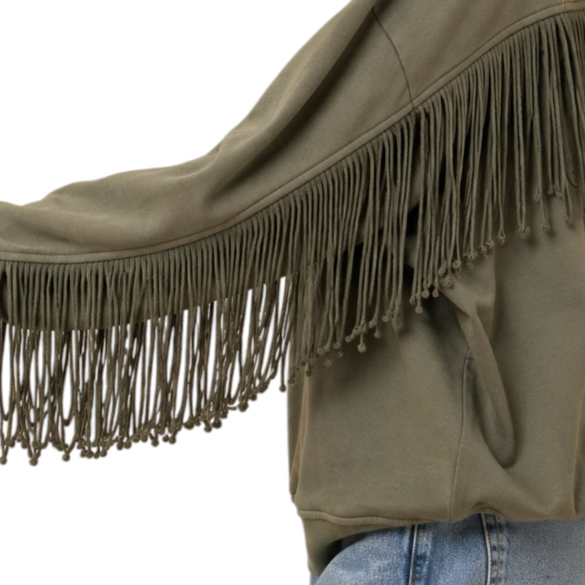 An olive green fringed jacket or shrug with long hanging fringe along the sleeve, shown on a model wearing blue jeans against a plain white background.