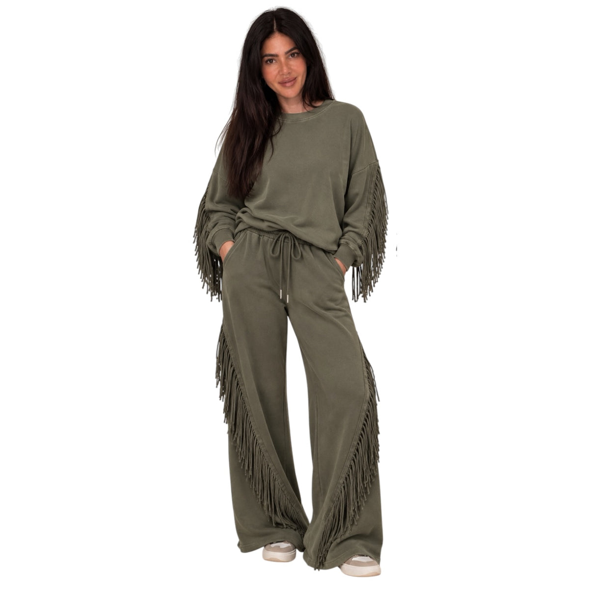 A woman modeling an olive green lounge set featuring a long-sleeve sweatshirt with fringe detailing on the sleeves and matching drawstring sweatpants, set against a plain white background.