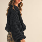 Woman wearing a black knitted sweater on a beige background