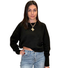 Woman wearing a black sweater and blue jeans on a white background