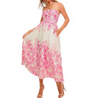a woman wearing an ivory pink floral dress with pocket on white background.