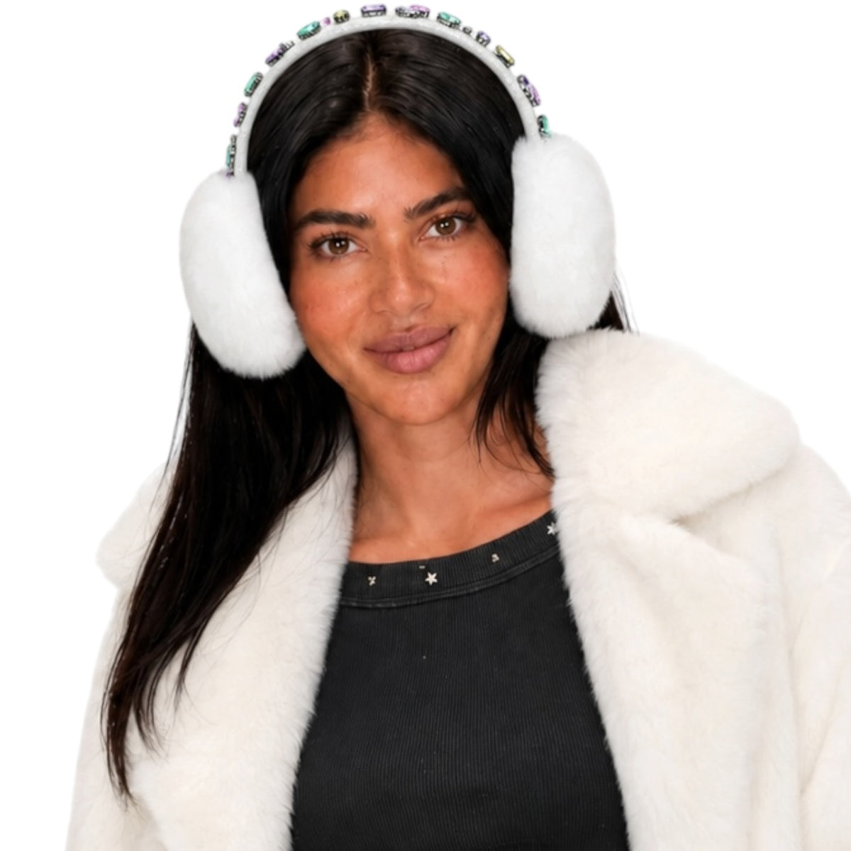 A woman wearing fluffy white earmuffs with a jeweled headband, a black top, and a white faux fur coat, photographed against a solid white background.