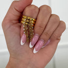 Hand wearing gold ring with chains on a white background