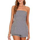Woman wearing a black and white checkered strapless set on a white background