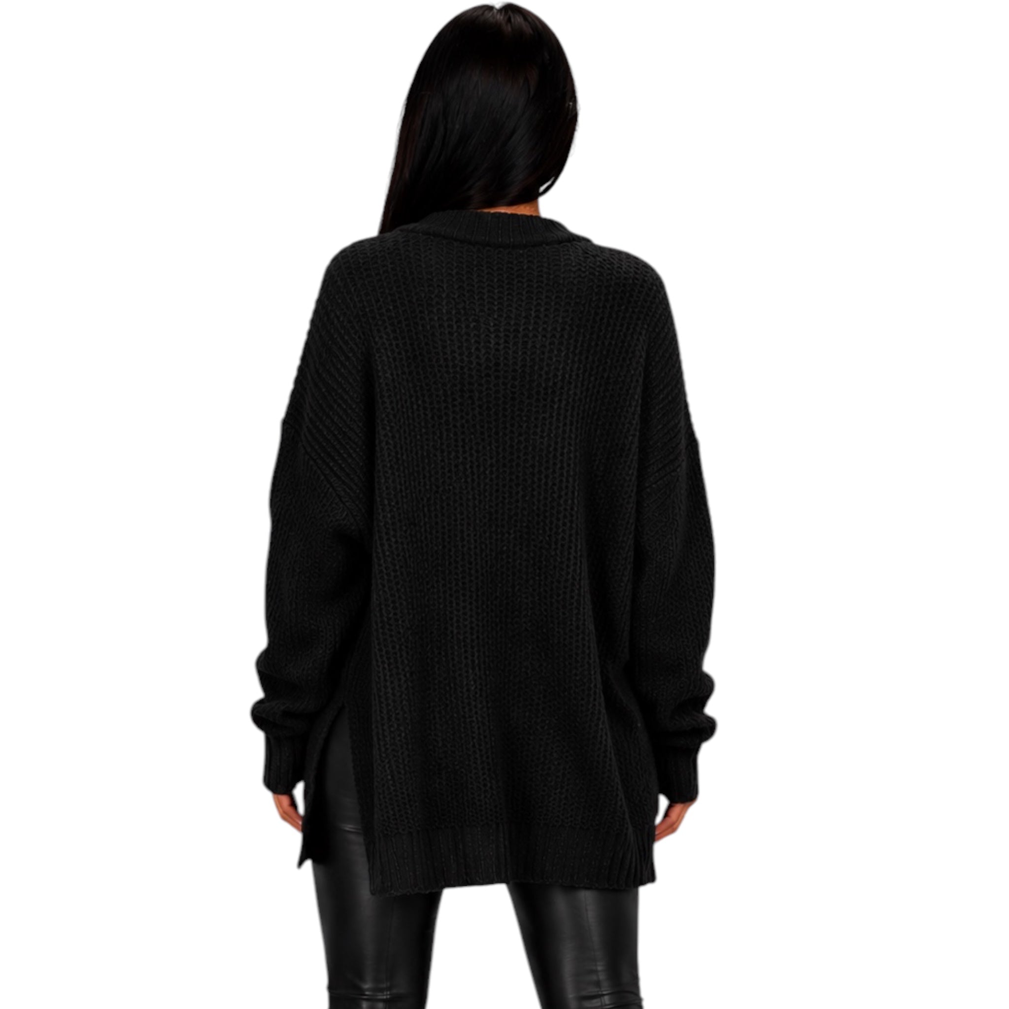 A woman viewed from the back wearing an oversized black textured knit sweater and black pants against a plain white background.