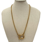 Gold chain necklace on a mannequin bust with a beige background