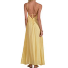 Yellow dress with open back worn by a person on a white background