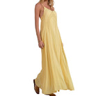 Woman wearing a yellow sleeveless dress on a white background