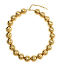 Gold necklace with round beads on a white background