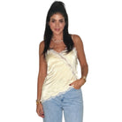 woman wearing yellow satin cami with white lace on white background