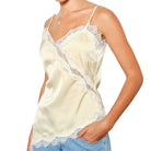 woman wearing yellow satin cami with white lace on white background
