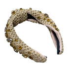 Decorative headband with textured band and embellishments on a white background