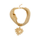 Gold necklace with a heart-shaped pendant on a white background