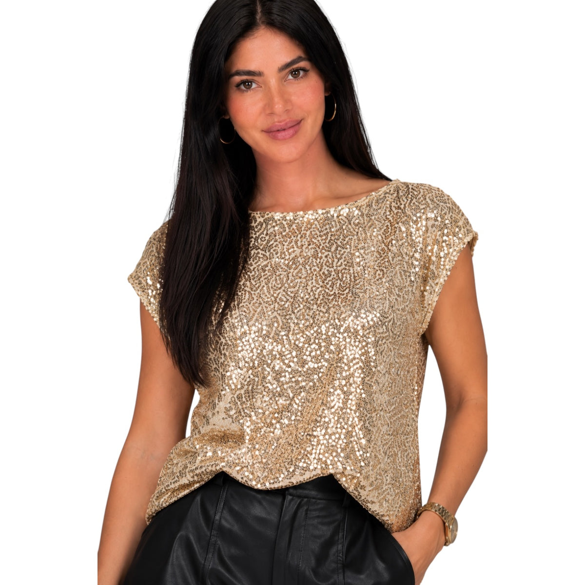 A woman wearing a gold sequined short-sleeve top and black pants, photographed against a plain white background.