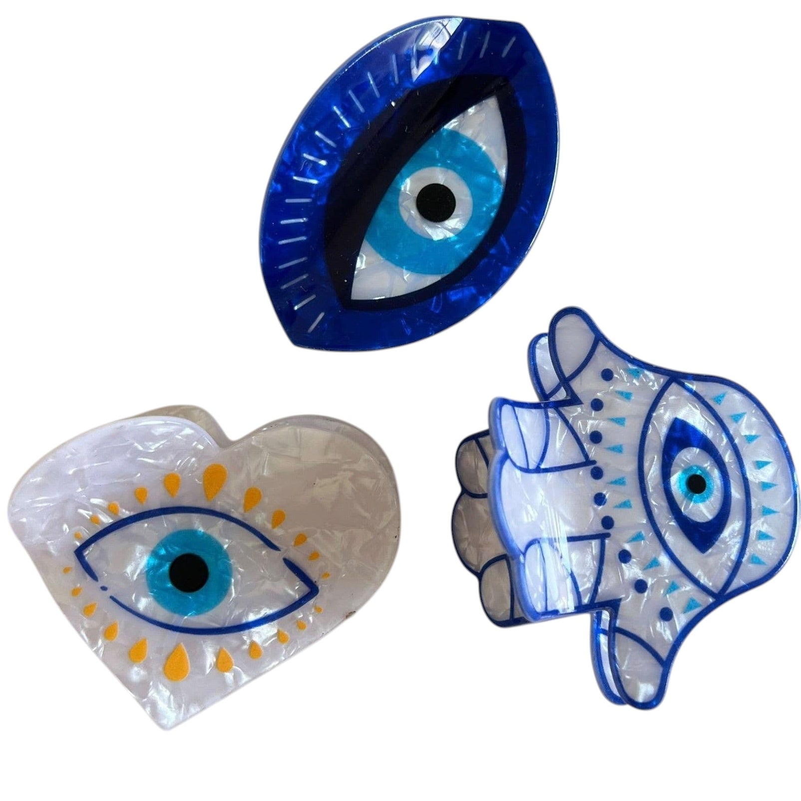 Three claw clips with eye designs on a white background