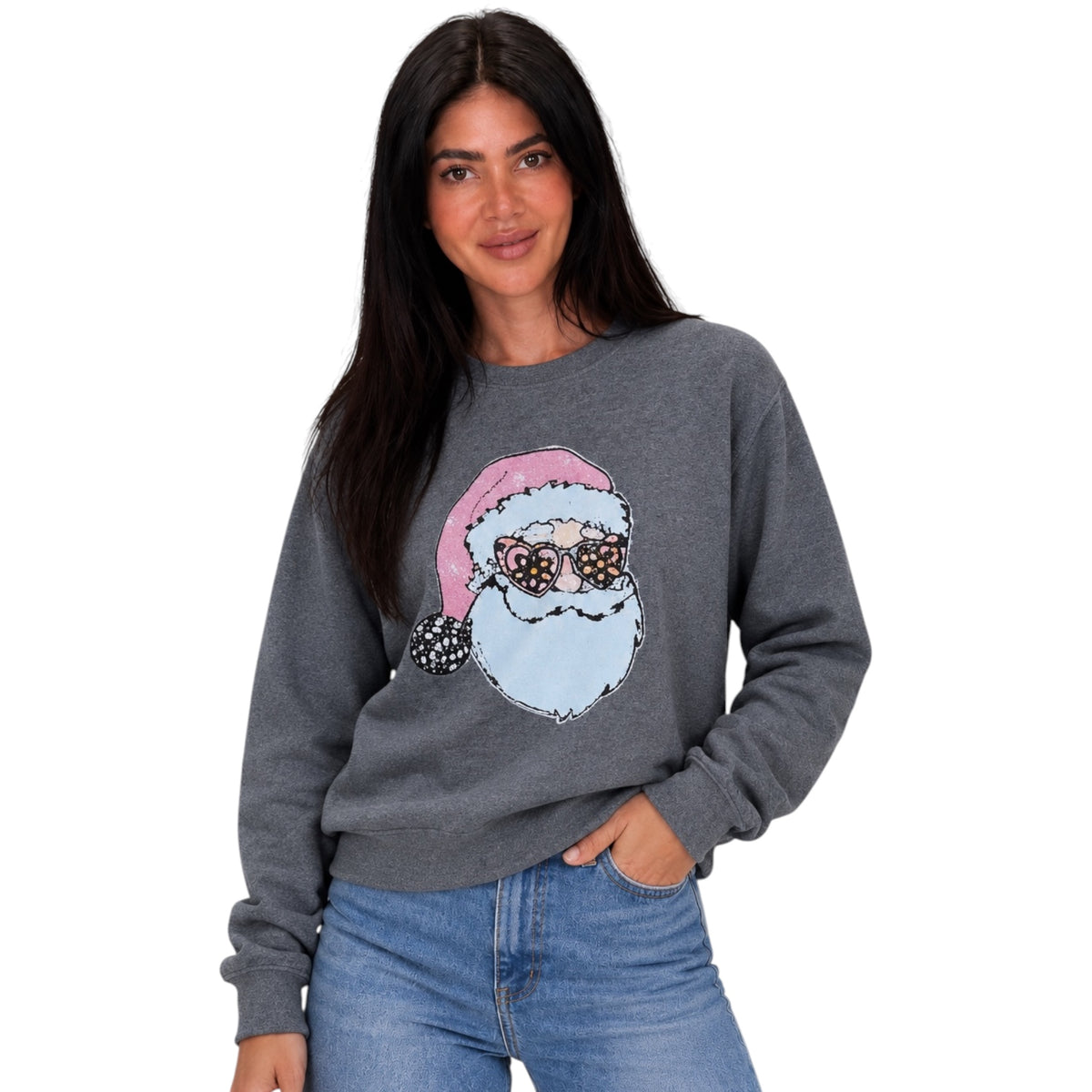 A woman wearing a dark gray crewneck sweatshirt with a graphic of a Santa Claus face wearing pink sunglasses, paired with blue jeans, against a plain white background.