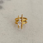 Gold ring with a central gemstone on a gray background