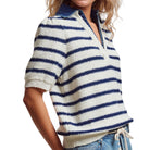 Person wearing a blue and white striped sweater with a white background