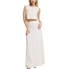 Woman wearing a white sleeveless top and long skirt on a white background